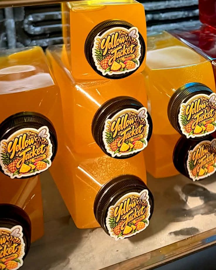 Yellow Jacket bottles in the fridge with flavor names on their caps